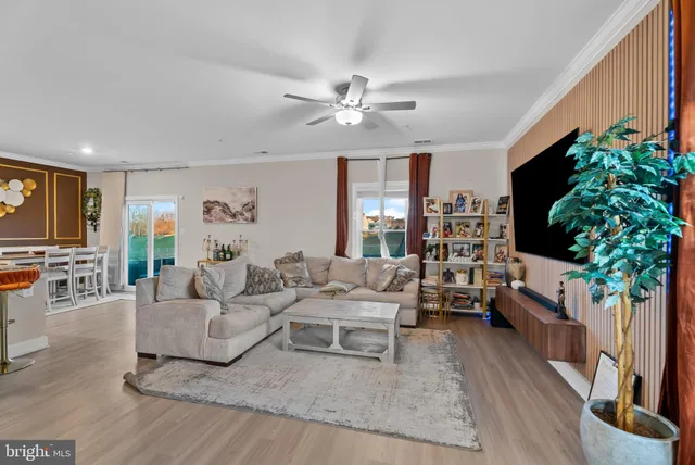 a living room with furniture a potted plant and a flat screen tv