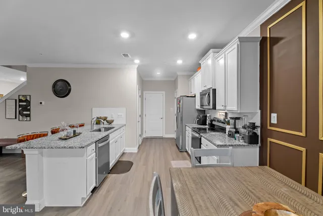 a kitchen that has a lot of cabinets a sink and appliances in it