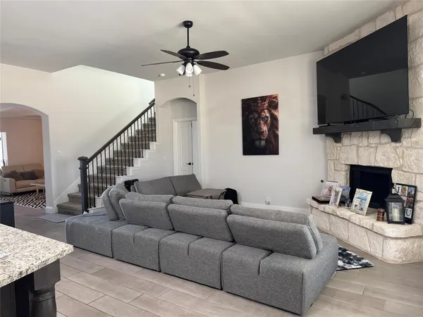 a living room with furniture a flat screen tv and a fireplace