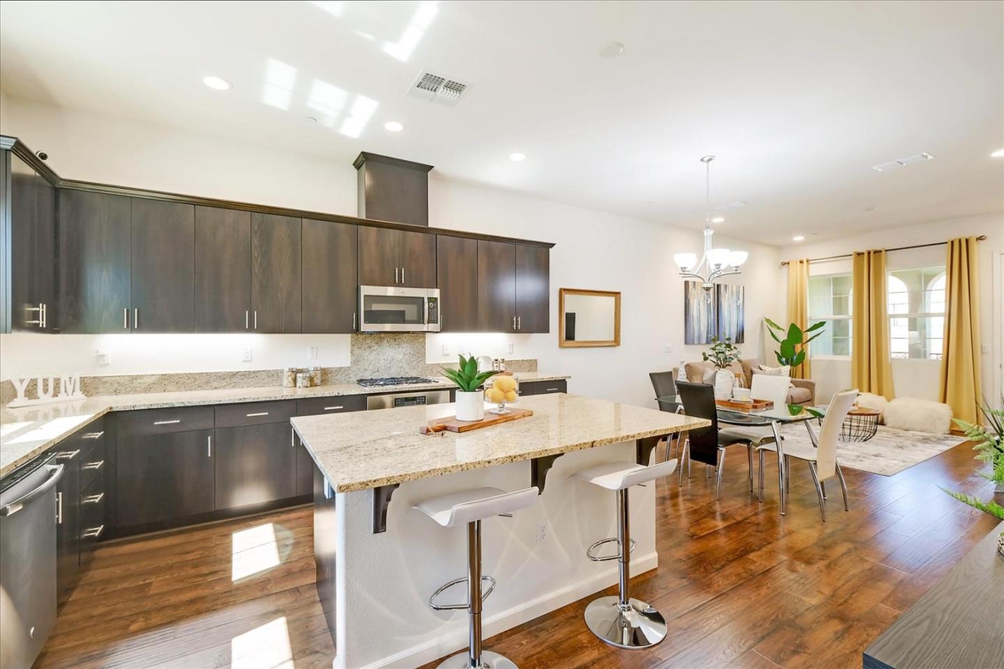 39846 Sawyer Terrace Newark, CA 94560 - Photo 8 of 21 a open kitchen with stainless steel appliances granite countertop a stove top oven a dining table and chairs with wooden floor