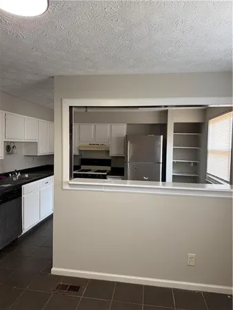 a living room with a large window and stainless steel appliances