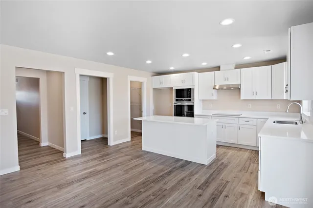 a kitchen with a refrigerator and a stove top oven