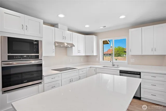 a kitchen with white cabinets and sink