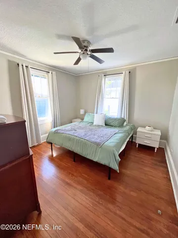 a bedroom with a bed and wooden floor