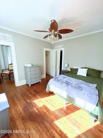 a bedroom with a bed and wooden floor