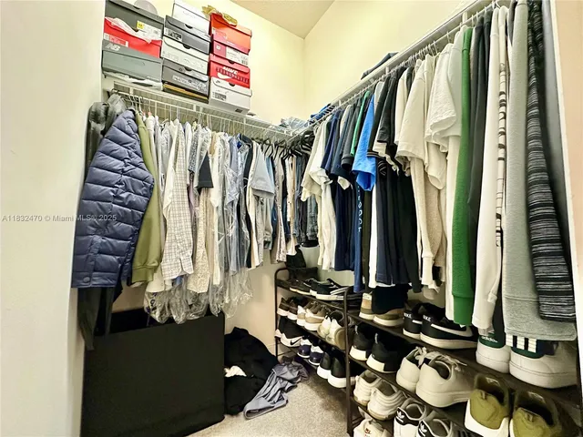 a view of walk in closet with clothes