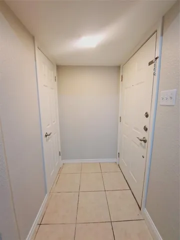 a view of an empty room with wooden floor and window