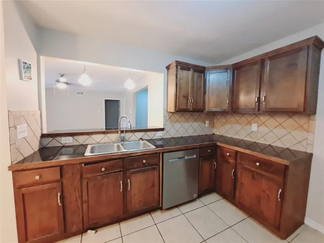 a kitchen with granite countertop a stove top oven microwave and cabinets