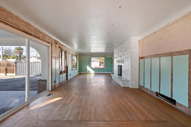 a view of a hallway with wooden floor and stairs