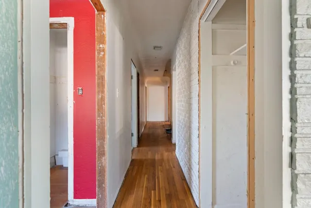 a view of a hallway with wooden floor and glass door