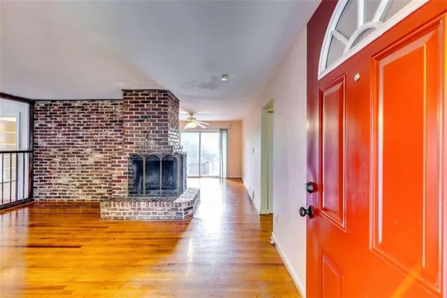 a view of a livingroom with wooden floor and a fireplace