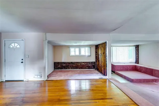 a spacious bedroom with a bed and wooden floor