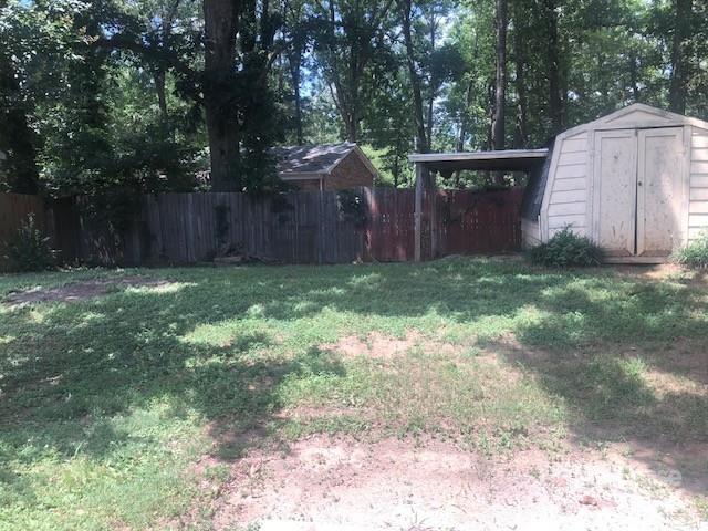 5904 White Cliffs Drive Monroe, NC 28110 - Photo 13 of 16 a view of a backyard with large trees and wooden fence