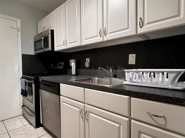 a kitchen with stainless steel appliances granite countertop a sink and a microwave