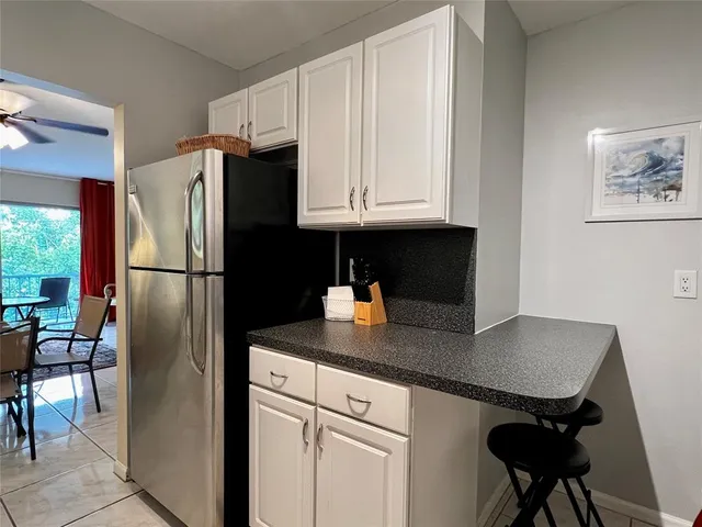 a kitchen with stainless steel appliances granite countertop a refrigerator a sink a stove and a refrigerator