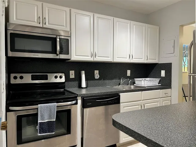 a kitchen with stainless steel appliances granite countertop a stove microwave and cabinets