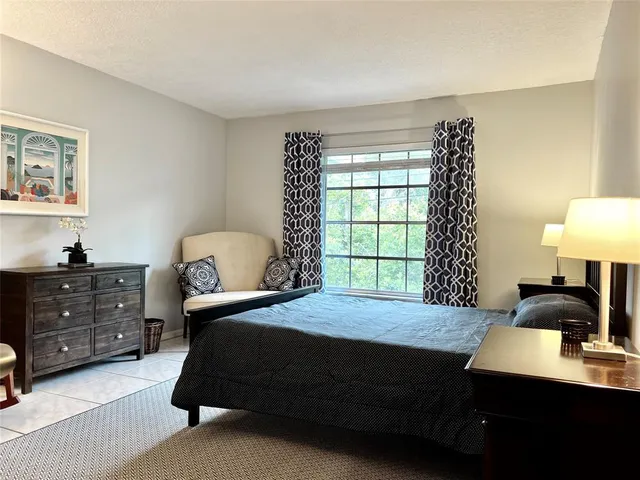 a bedroom with a bed window and a night stand