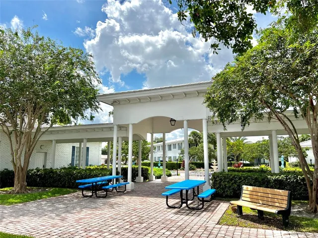 a view of backyard with table and chairs and a large tree