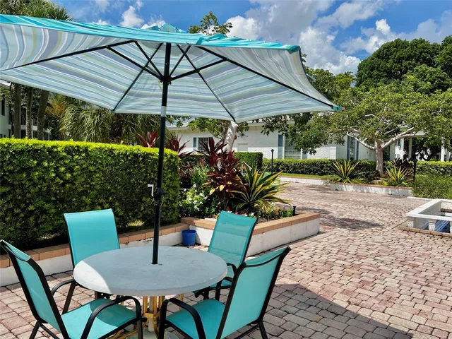 a patio with a table and chairs under an umbrella