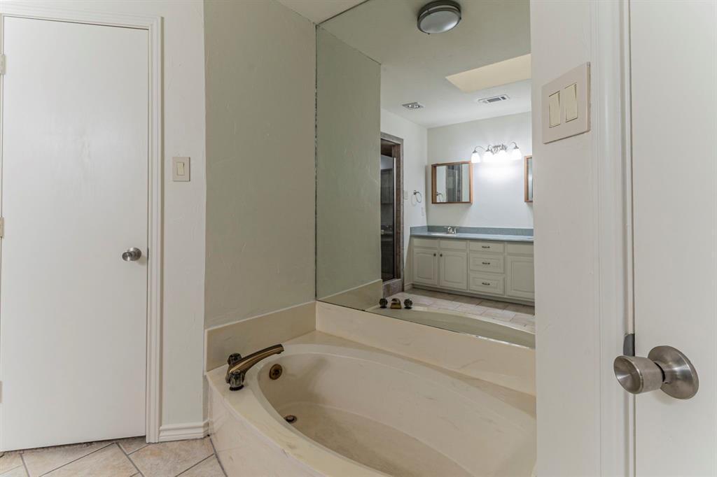 127 Nicklaus Nook Lancaster, TX 75146 - Photo 17 of 37 Full bathroom featuring double vanity, light tile patterned flooring, and a garden tub