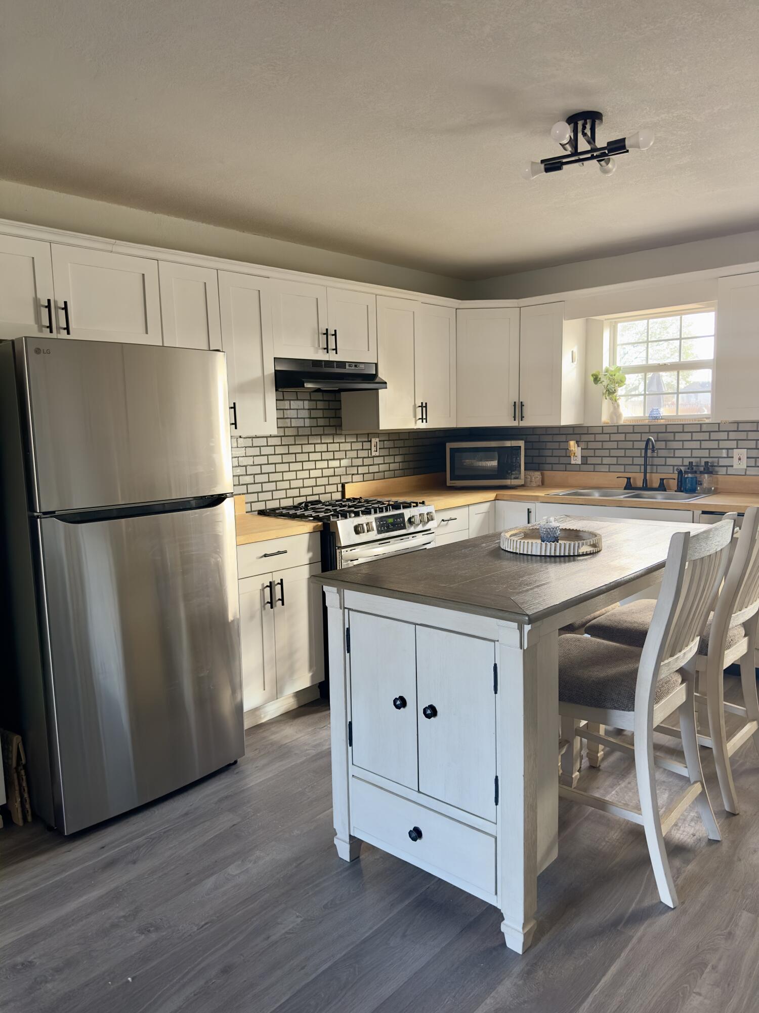 4807 39th Street Lubbock, TX 79414 - Photo 12 of 29 a kitchen with stainless steel appliances a refrigerator a sink a stove a table and chairs