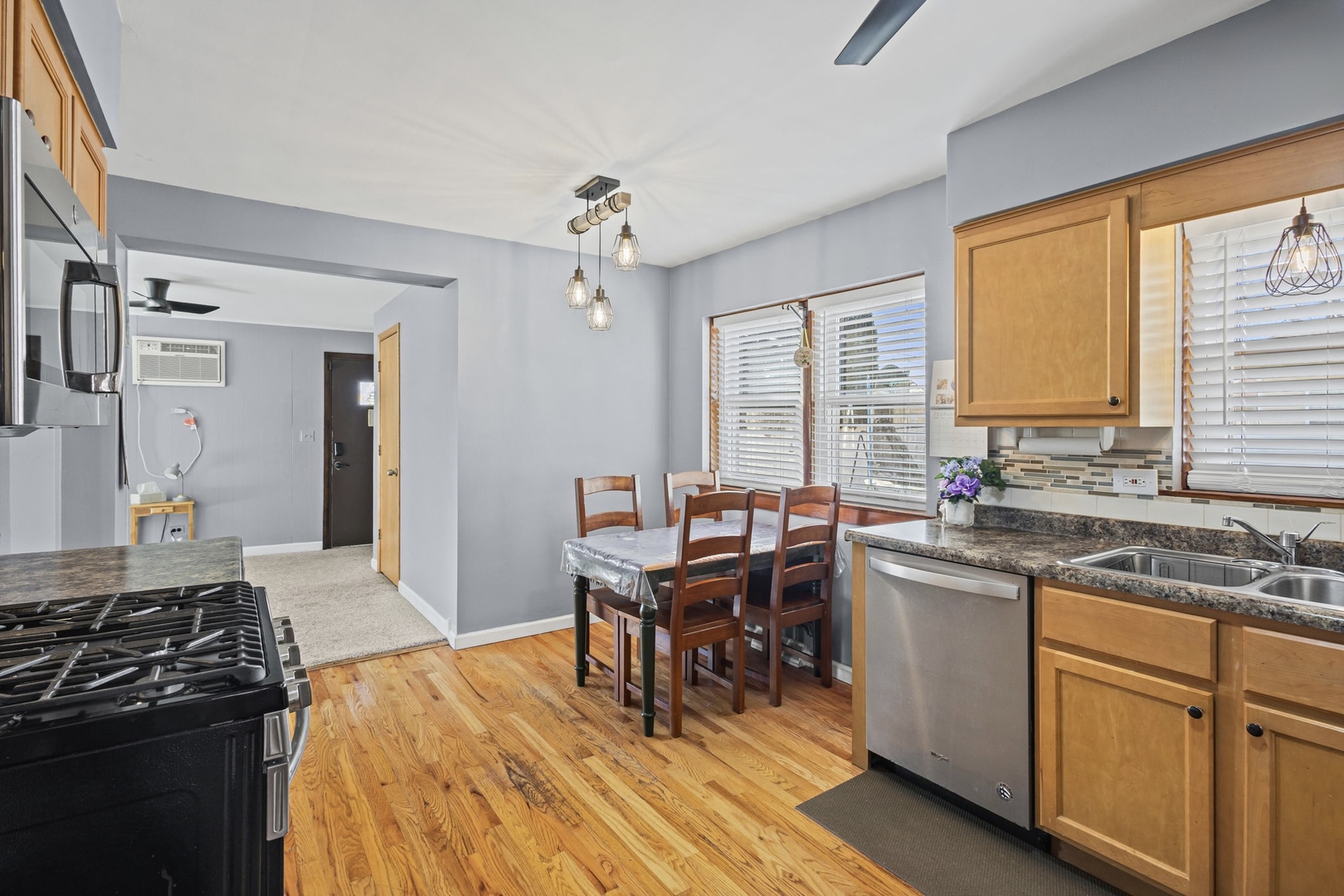5901 108th Place Chicago Ridge, IL 60415 - Photo 5 of 15 a kitchen with a stove a sink dishwasher a dining table and chairs with wooden floor