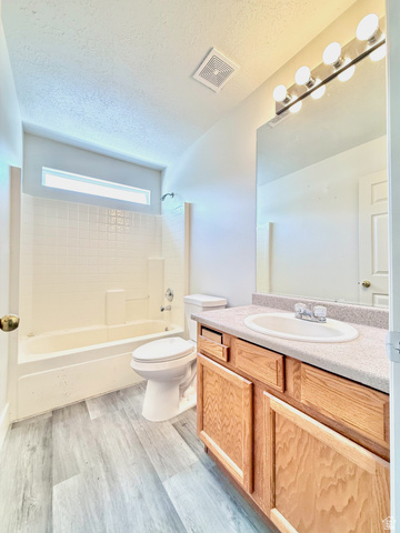 1705 80 East Tooele, UT 84074 - Photo 15 of 22 Light wood-finish vanity with a built-in sink, paired with a large mirror and multi-bulb vanity lighting