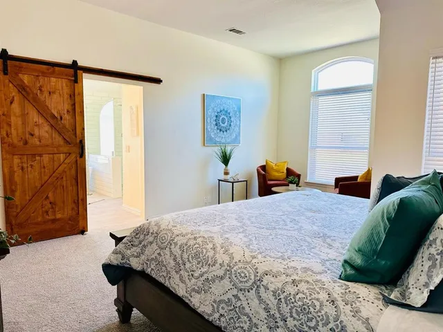 a bathroom with a white tub a mirror and a window