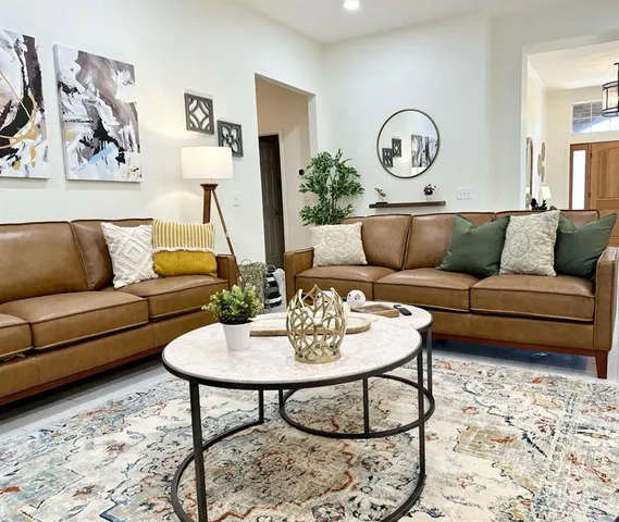 a living room with furniture a rug and a wall painting