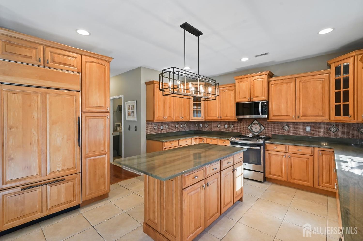 15 Rues Road Cream Ridge, NJ 08514 - Photo 17 of 49 a kitchen with stainless steel appliances granite countertop a stove top oven a sink dishwasher a dining table and chairs with wooden floor