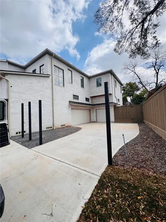 a view of a white house with a large tree