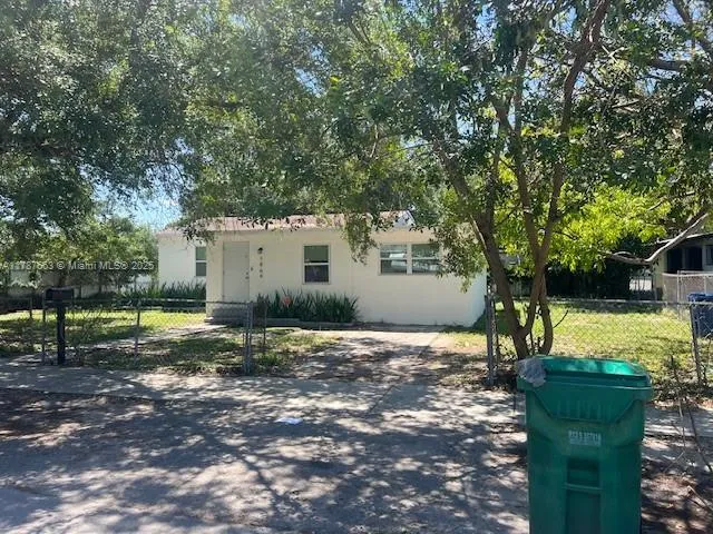 a view of a house with backyard and a tree