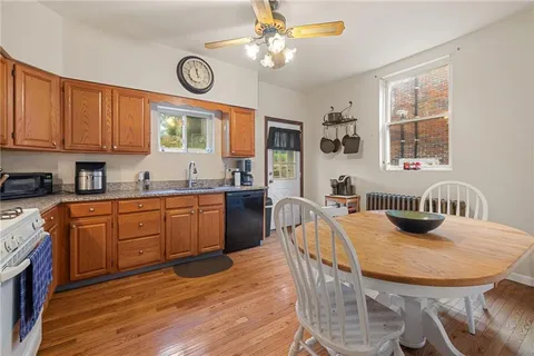 a kitchen with stainless steel appliances granite countertop a stove a kitchen island a dining table and chairs