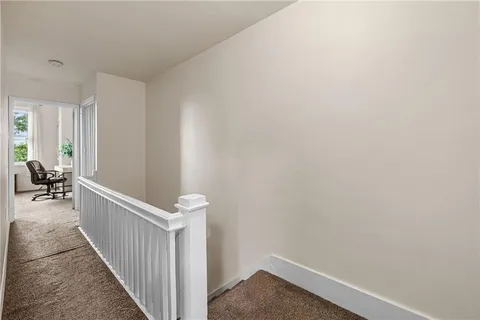 a view of a hallway to a livingroom with furniture