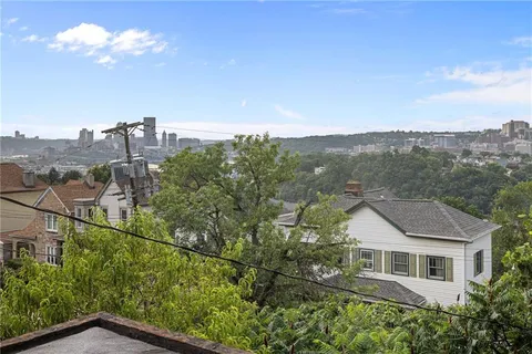 a aerial view of a house with a yard and balcony