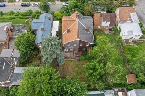 an aerial view of residential houses with outdoor space and street view