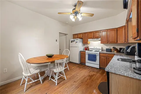 a kitchen with granite countertop kitchen island stainless steel appliances a sink a stove a refrigerator cabinets and a dining table