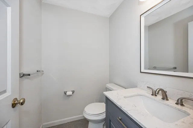 a bathroom with a granite countertop sink a mirror and toilet