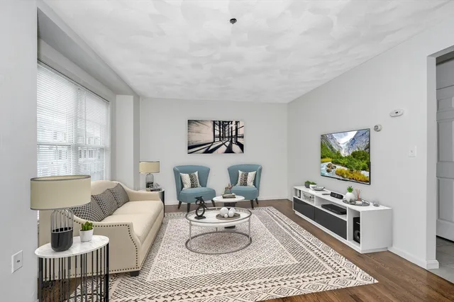 a living room with furniture a rug and a window