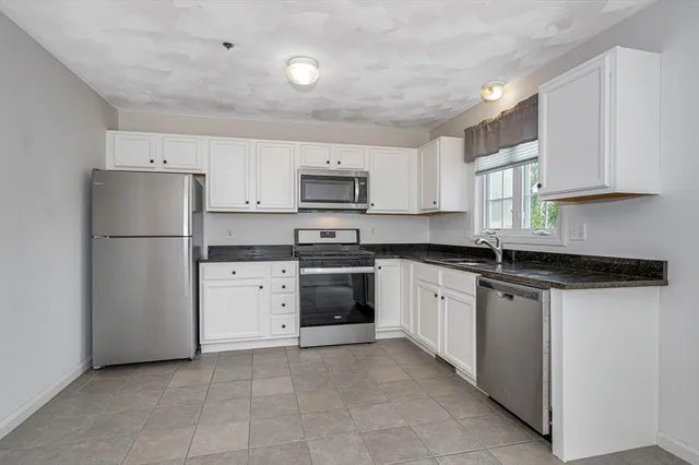 a kitchen with a refrigerator sink and cabinets