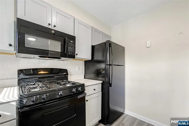 a kitchen with stainless steel appliances a stove microwave and refrigerator