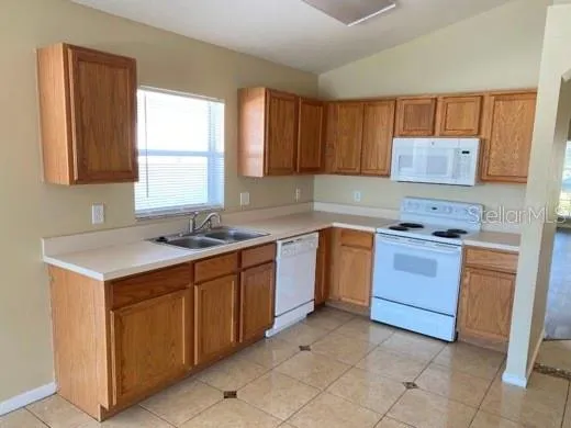 a kitchen with a stove sink and cabinets
