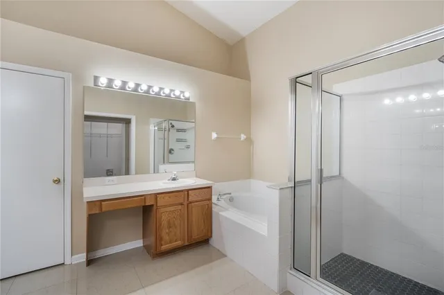 a bathroom with a double vanity sink mirror and bathtub