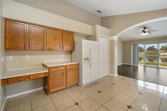 a kitchen with granite countertop a refrigerator and white cabinets