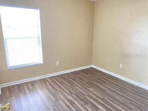 a view of an empty room with wooden floor