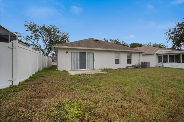 a view of a yard in front of a house with a large tree