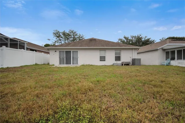 a front view of house with yard and trees in the background