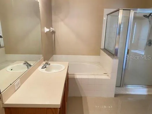 a bathroom with a sink a tub and a mirror