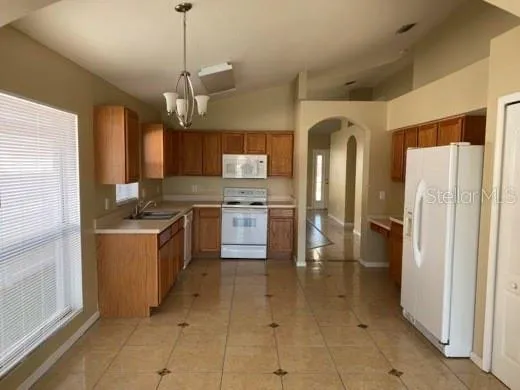 a kitchen with stainless steel appliances granite countertop a refrigerator a oven a sink and dishwasher
