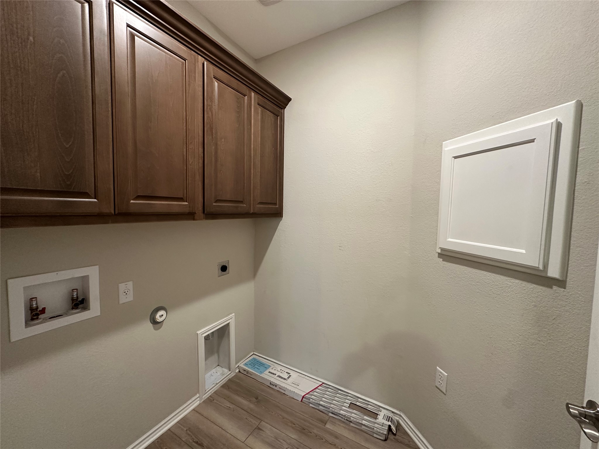 219 Coachsmith Street Georgetown, TX 78633 - Photo 20 of 25 Laundry area featuring washer hookup, hookup for a gas dryer, hookup for an electric dryer, wood finished floors, and cabinet space
